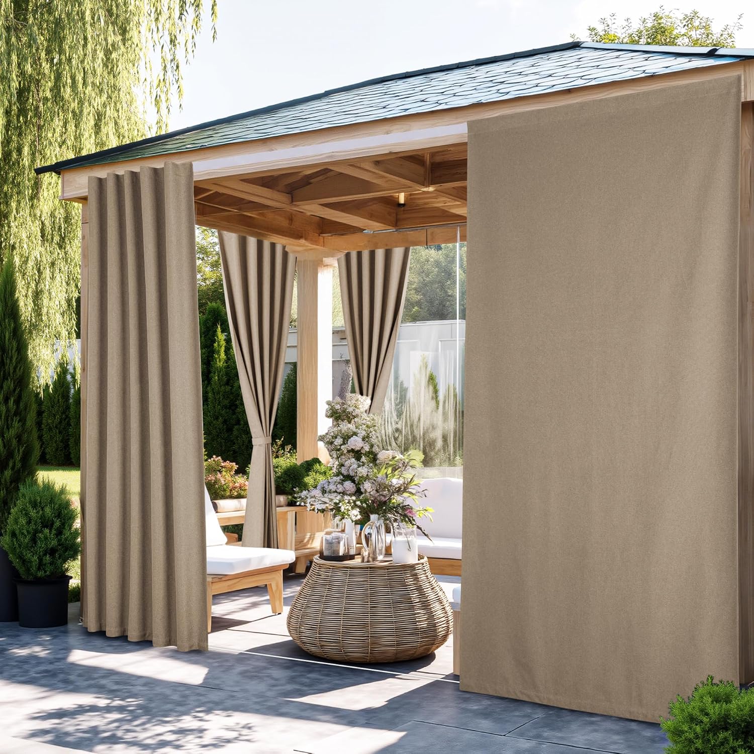 Beige outdoor privacy curtains on a wooden gazebo, shading a patio with white cushioned furniture.
