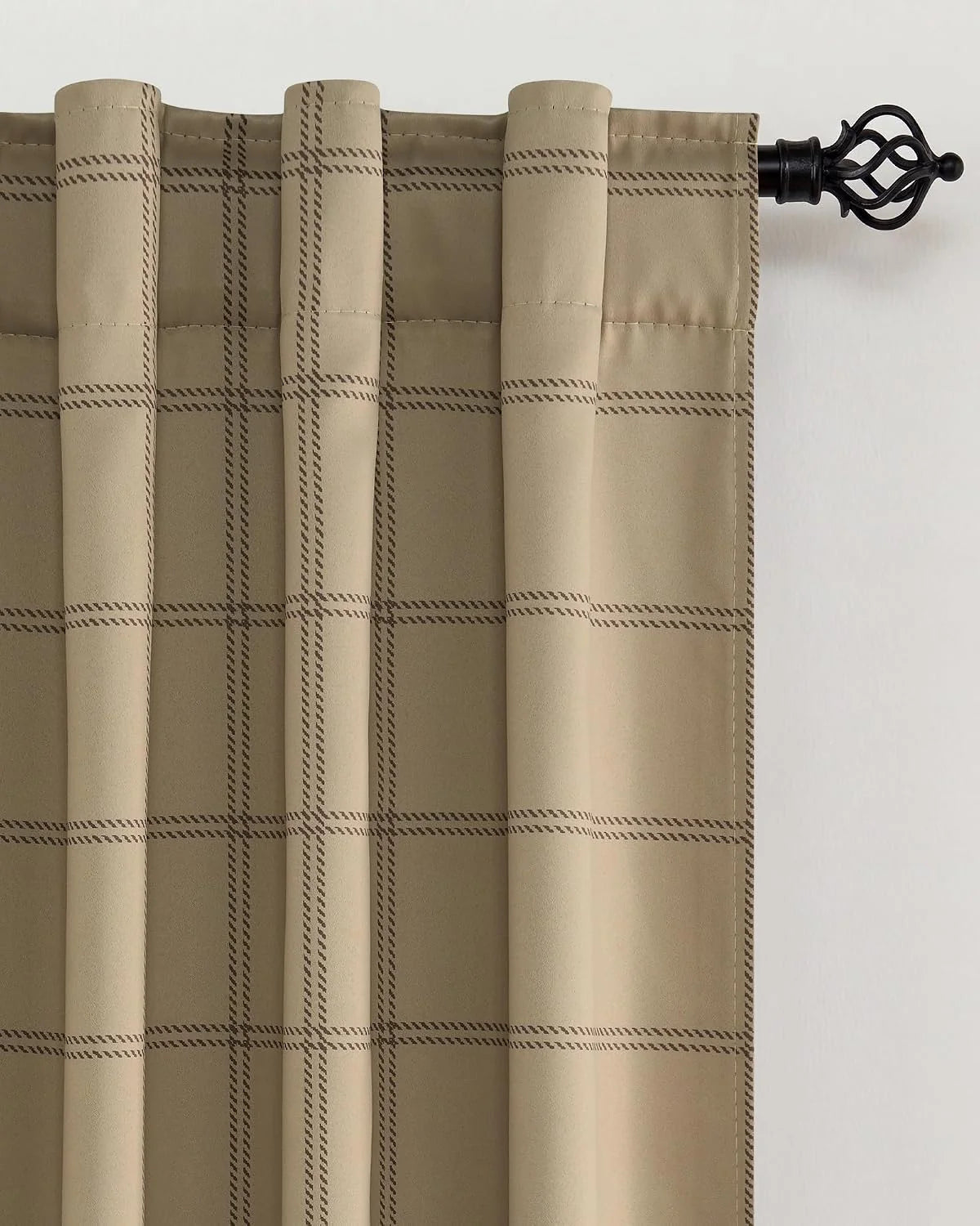 Beige plaid curtain panel with rod pocket top hanging on a black decorative rod