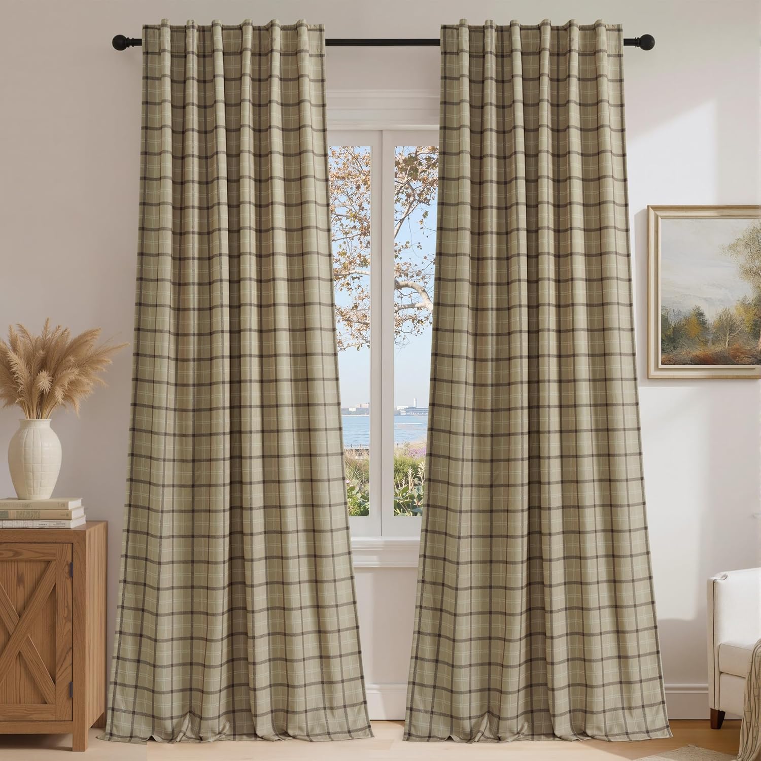 Beige and brown plaid rod pocket curtains hang on a black rod, framing a bright window with an ocean view.