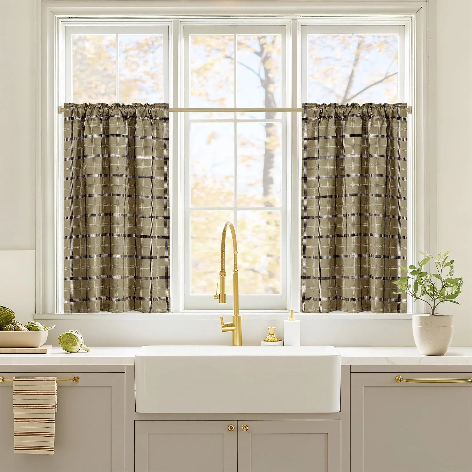 Beige plaid tier curtains on a white kitchen window above a farmhouse sink