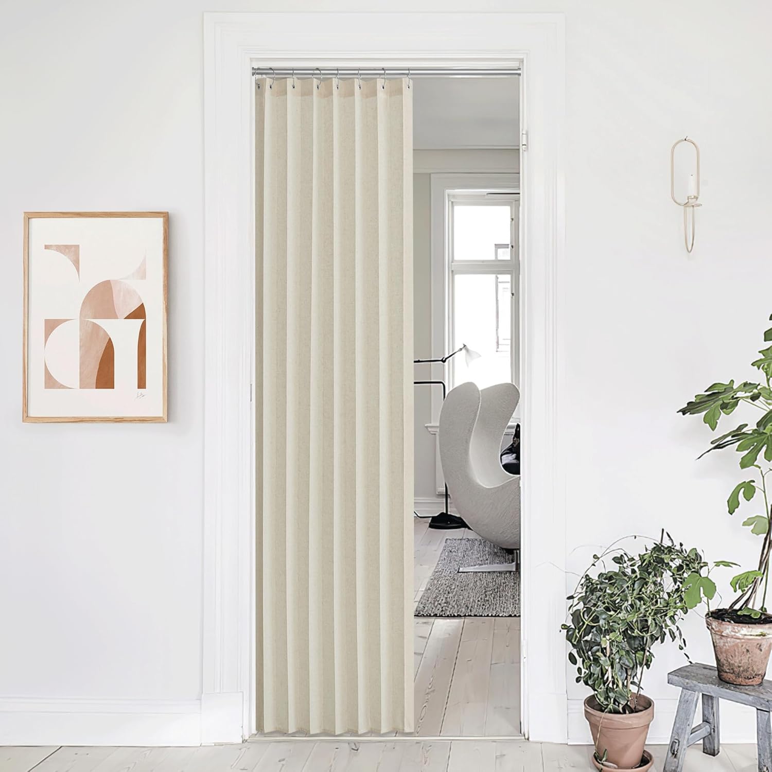 Light beige pleated fabric doorway curtain on a silver rod, providing privacy between two modern rooms.