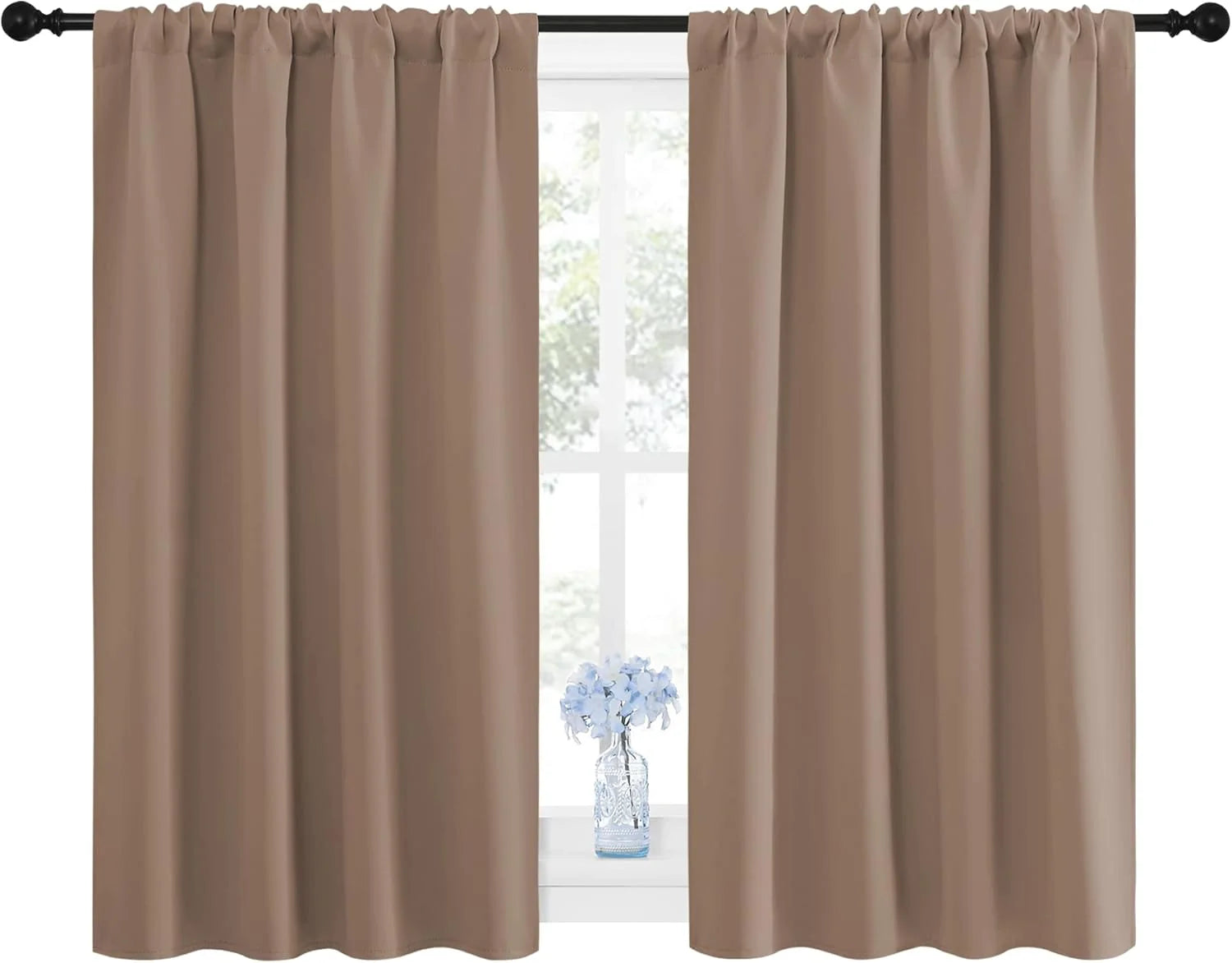 Pair of beige rod pocket curtains covering a window, with a small flower vase.