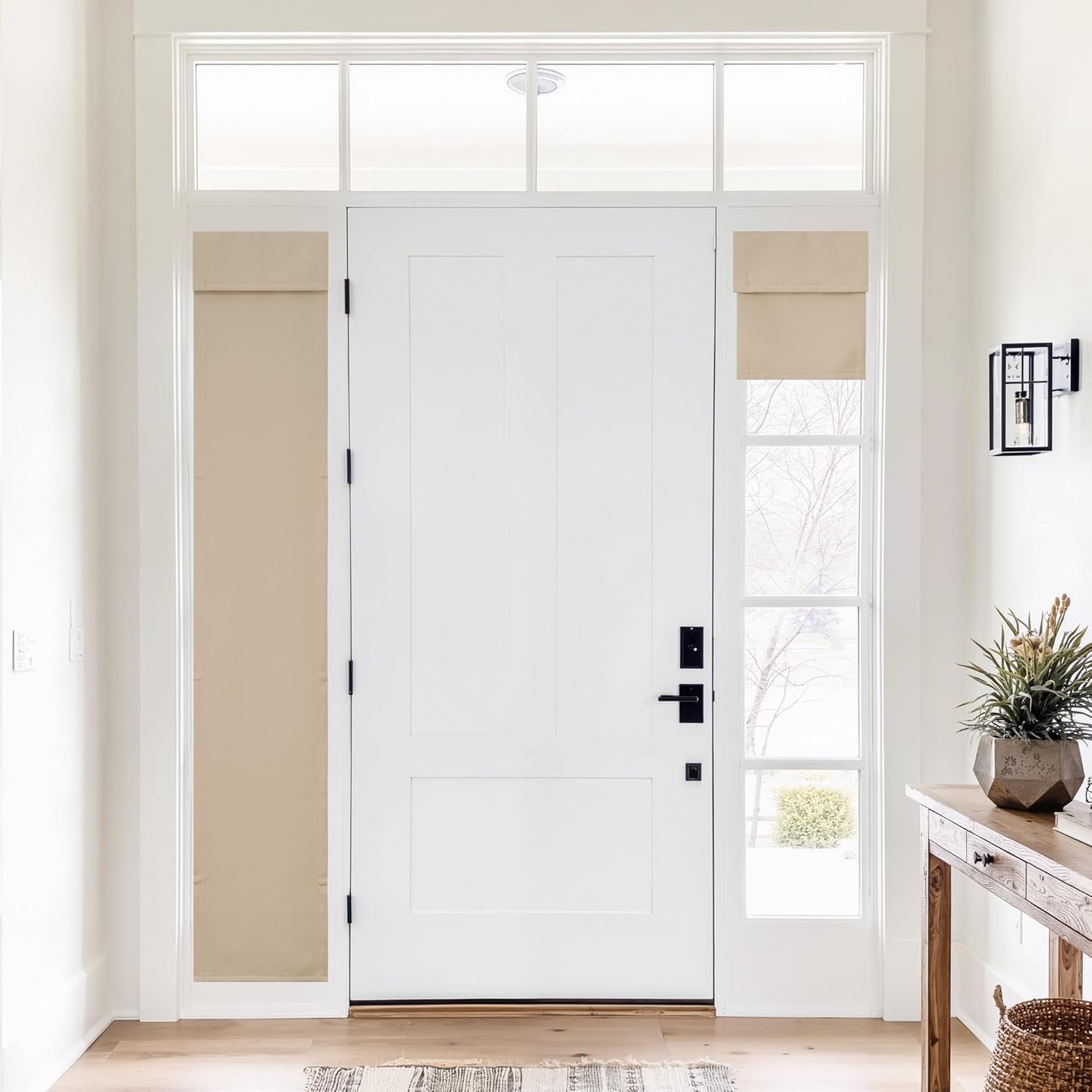 Natural beige roman blinds installed on narrow sidelight windows flanking a modern white entry door.