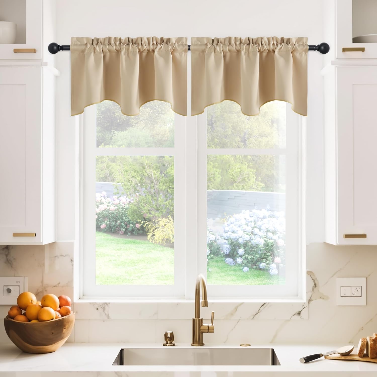 Light beige gathered rod pocket valance with a scalloped bottom edge hangs over a kitchen window.