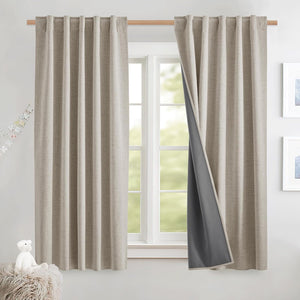 Light beige textured back-tab curtains with dark gray blackout lining, hanging on a wooden rod over a window.