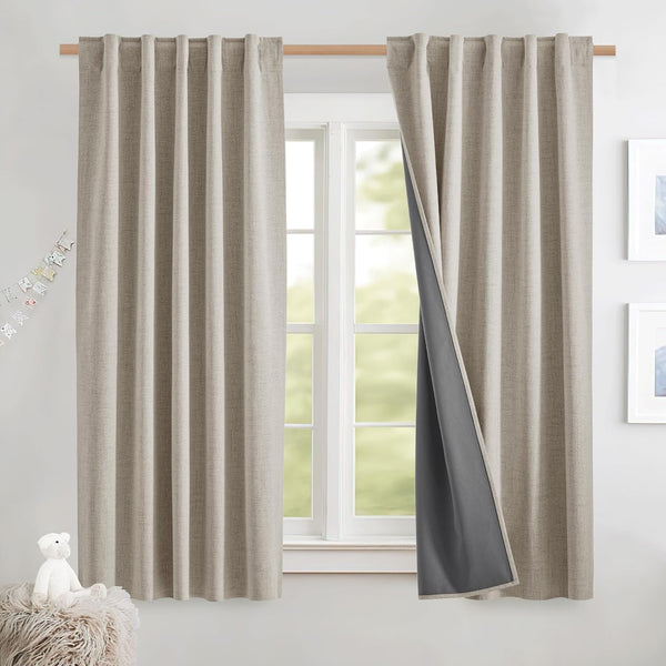 Light beige textured back-tab curtains with dark gray blackout lining, hanging on a wooden rod over a window.
