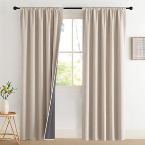 Beige textured rod pocket blackout curtains hung on a black rod, showing dark gray lining.