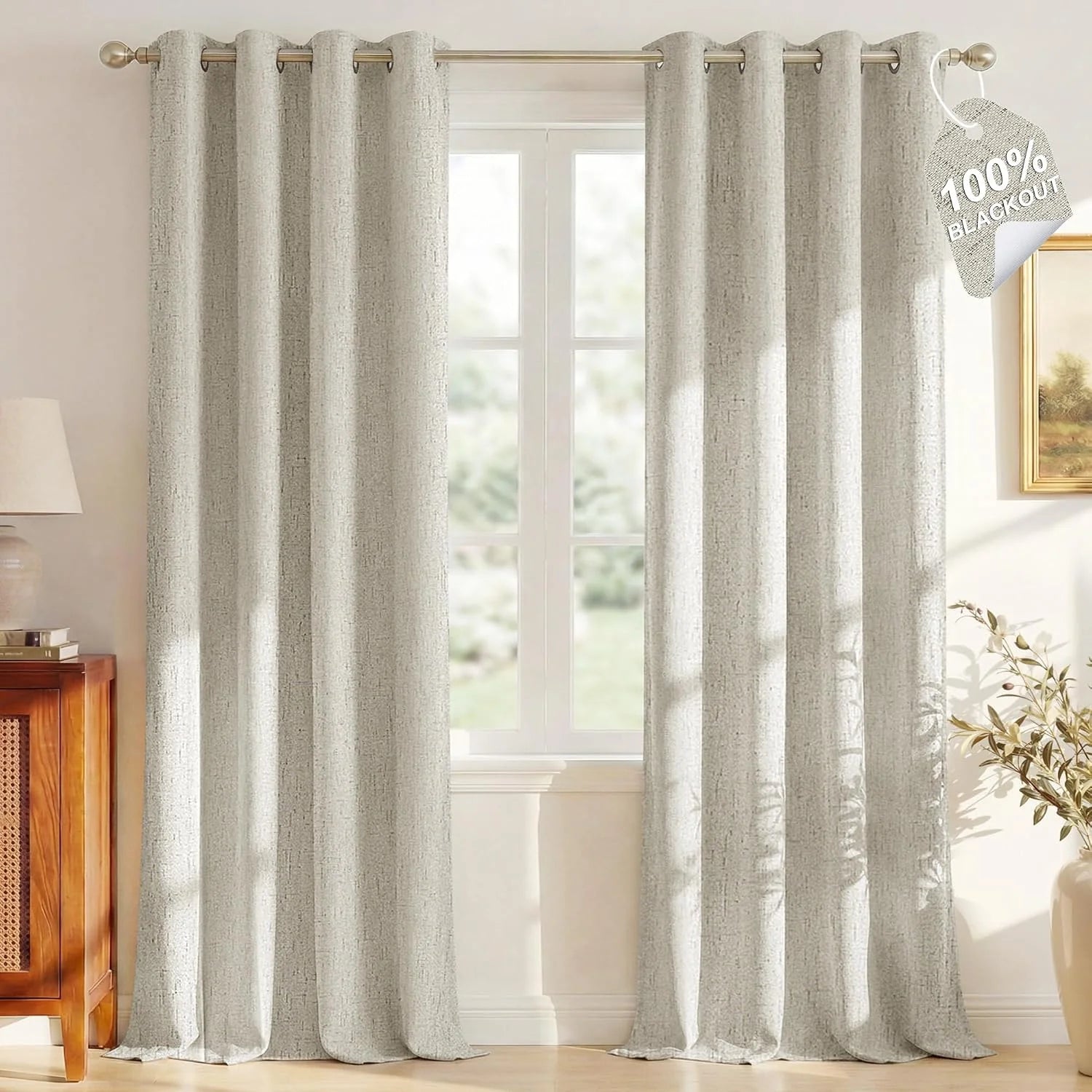 Beige textured blackout curtains with grommet top hanging in a bright living room