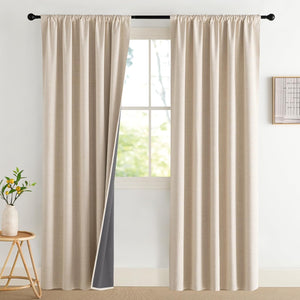 Beige textured rod pocket curtains with dark gray blackout lining hanging from a black rod in a bright room.