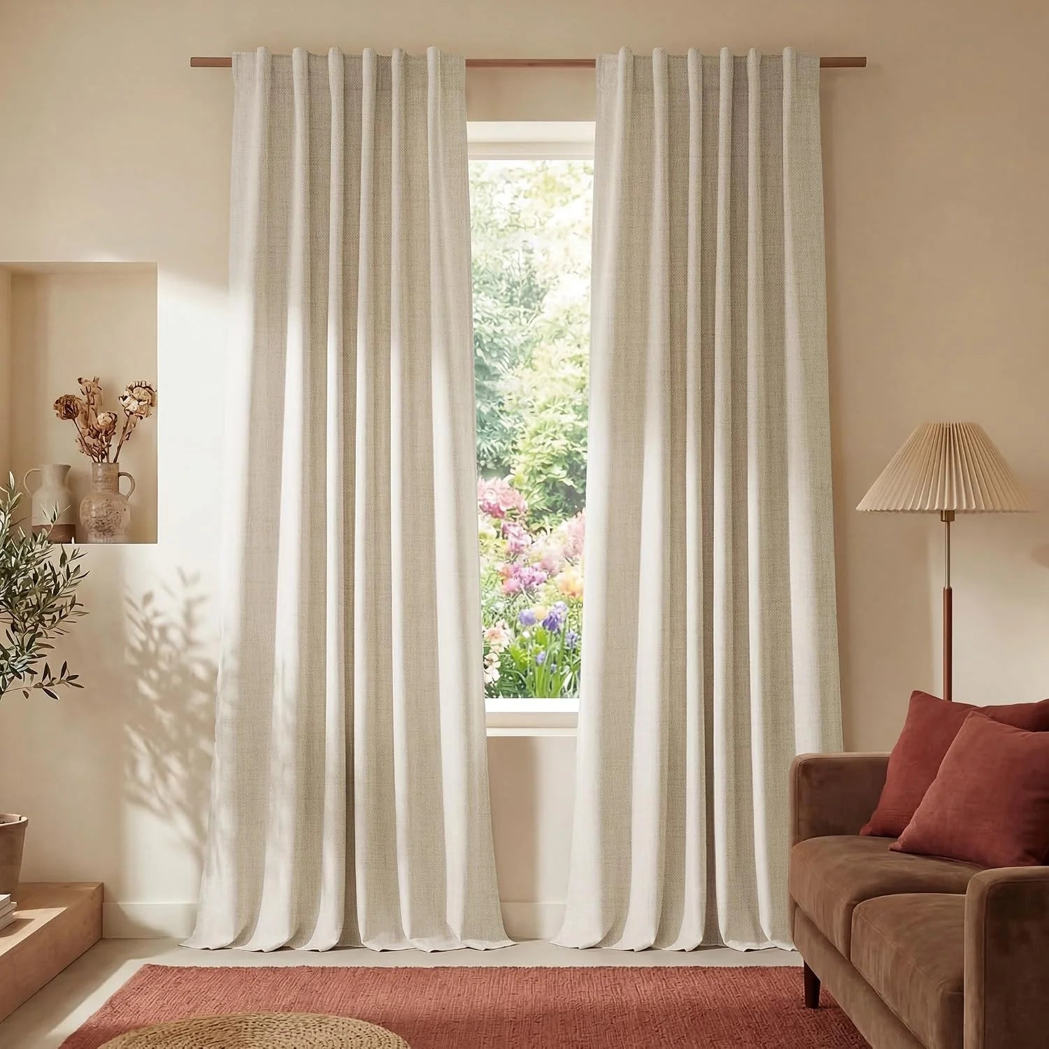 Light beige textured curtains on a wooden rod in a warm, bohemian living room overlooking a lush garden.