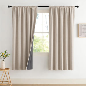 Beige textured rod pocket curtains with dark grey thermal blackout lining, hanging on a black rod.
