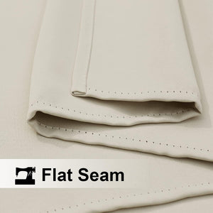 Close-up of light beige woven fabric showing a neat, flat seam with visible, even stitching.