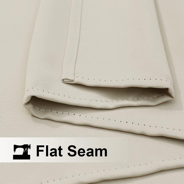 Close-up of light beige woven fabric showing a neat, flat seam with visible, even stitching.