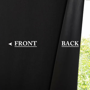 Close-up of black blackout curtain fabric, showing its smooth front and slightly textured back against a window.