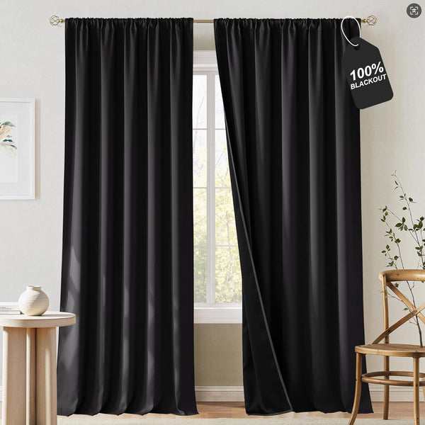 Solid black 100% blackout curtains with a gathered rod pocket top. One panel is slightly open.
