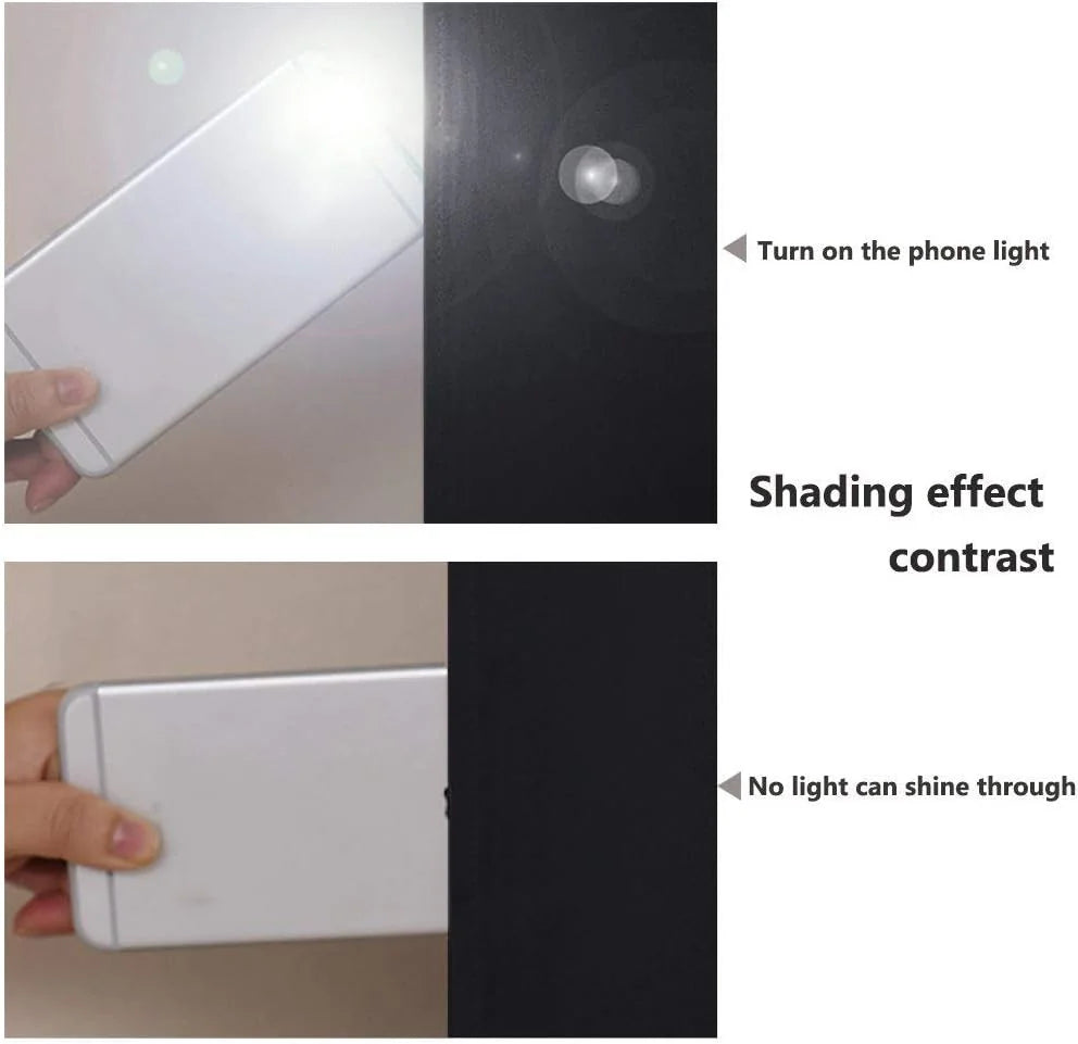 Hand holding a phone light behind black blackout fabric showing no light passes through