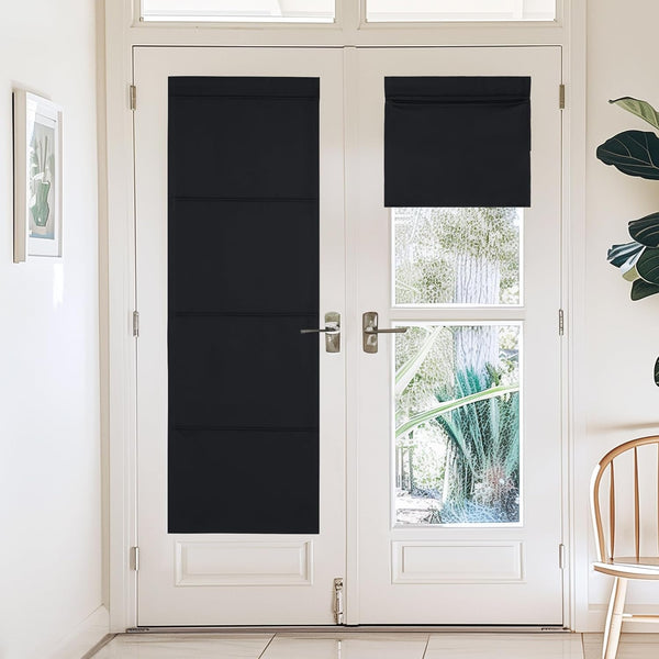 Black blackout shades cover white French door windows, one fully extended panel, one partially rolled up.