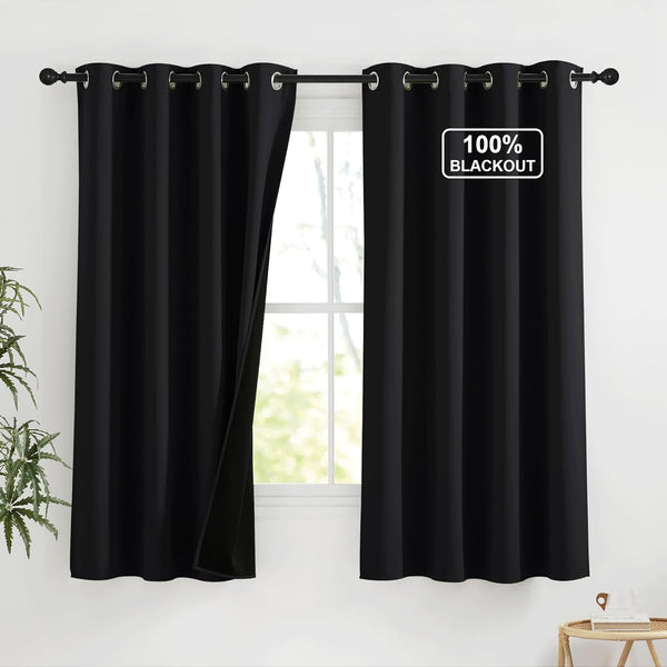 Black 100% blackout curtains with silver grommet tops on a rod. One panel open revealing bright window.