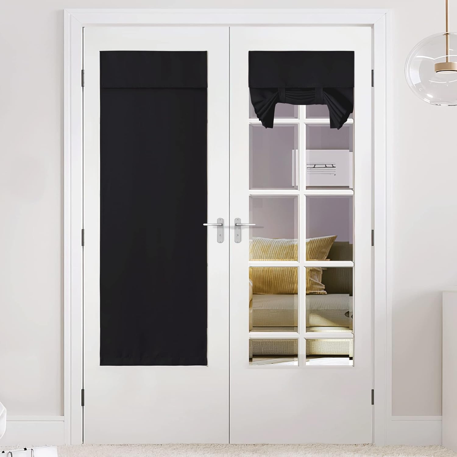 Black blackout shades installed on white French doors. One covers the full glass, the other is a tied-up valance.
