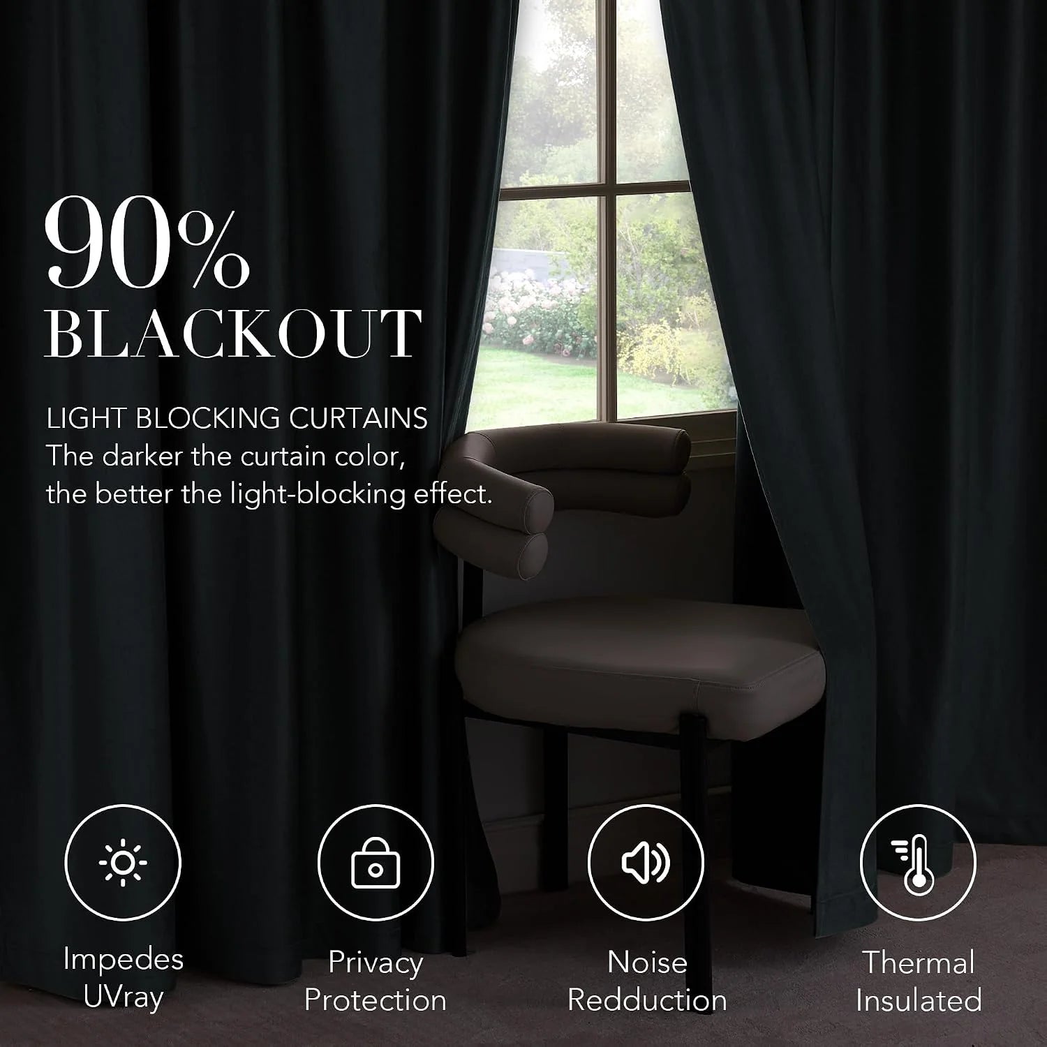 Black blackout curtains framing a window beside a modern accent chair indoors