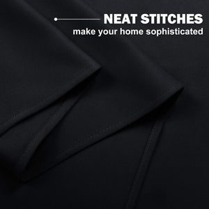 Black curtain fabric with neat, precise stitching visible on the folded hem, showcasing quality craftsmanship.