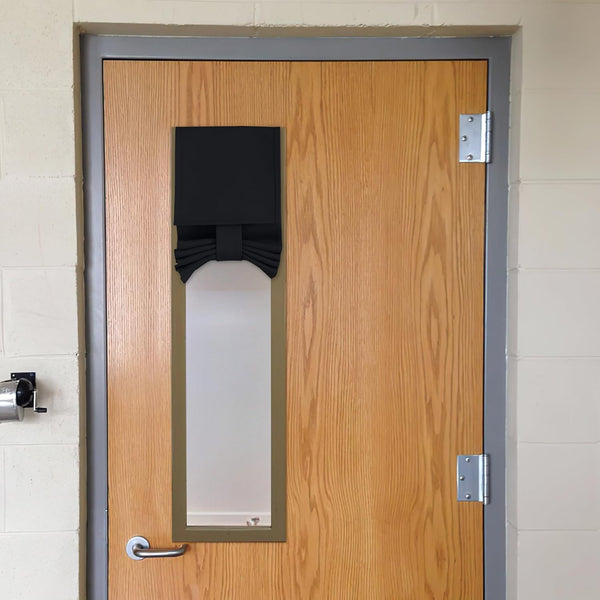 Black fabric door window privacy cover featuring a decorative bow, installed over a glass panel.