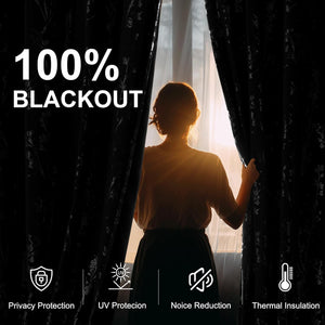 Person pulling back 100% blackout black floral curtains, demonstrating light blocking and thermal insulation.