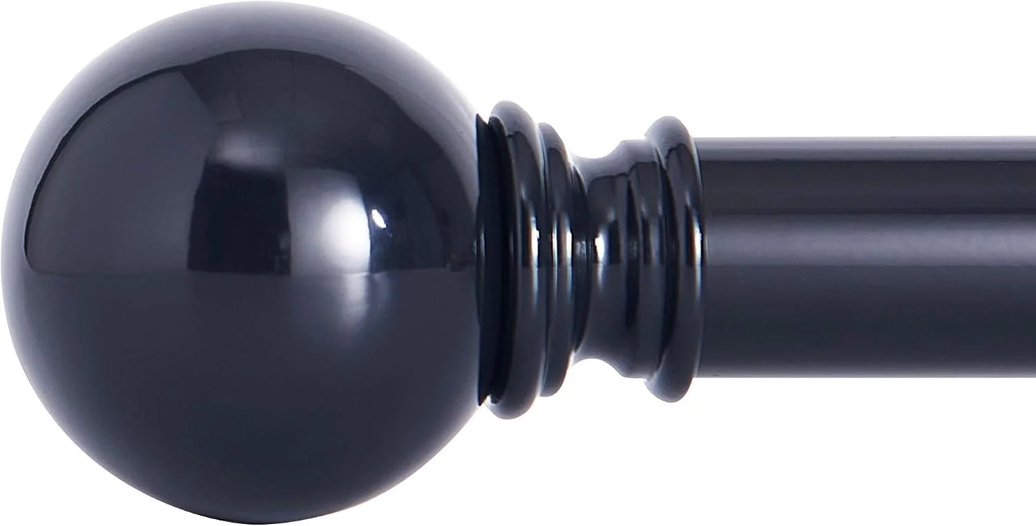 Close-up of a black glossy curtain rod with round ball finial and smooth metal pole
