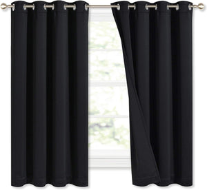Pair of black blackout curtains with silver grommet tops on a window rod. One panel is slightly open.