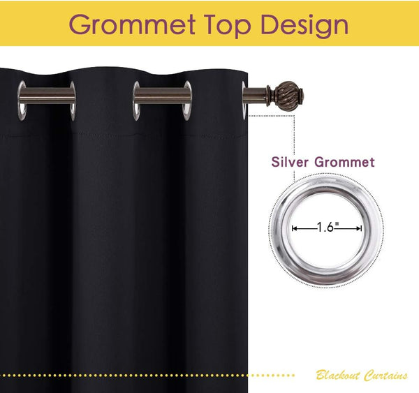Black blackout curtain with silver grommet top, hanging on a decorative bronze rod.