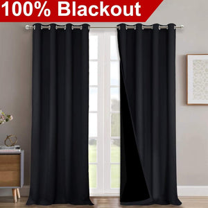 Thick black blackout curtains with silver grommet tops, showing dark lining, hanging over a white French door.