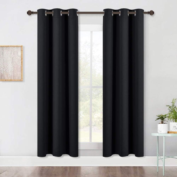 Two panels of black grommet top blackout curtains hanging on a bronze rod over a window.
