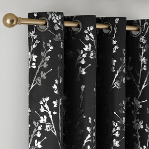 Black curtains with metallic silver floral branch pattern and shiny grommet tops on a gold rod