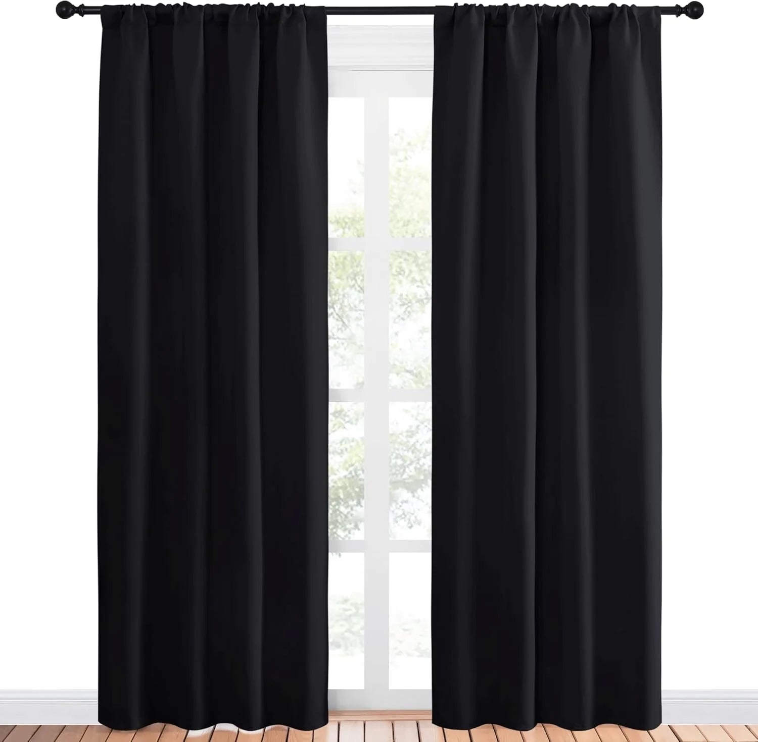 Black rod pocket blackout curtains hanging on a black curtain rod over a window