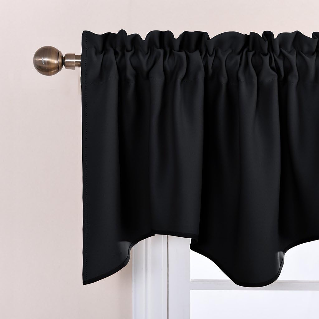 Solid black rod pocket valance with ruffled top and subtle scalloped bottom edge hanging on a brass curtain rod.