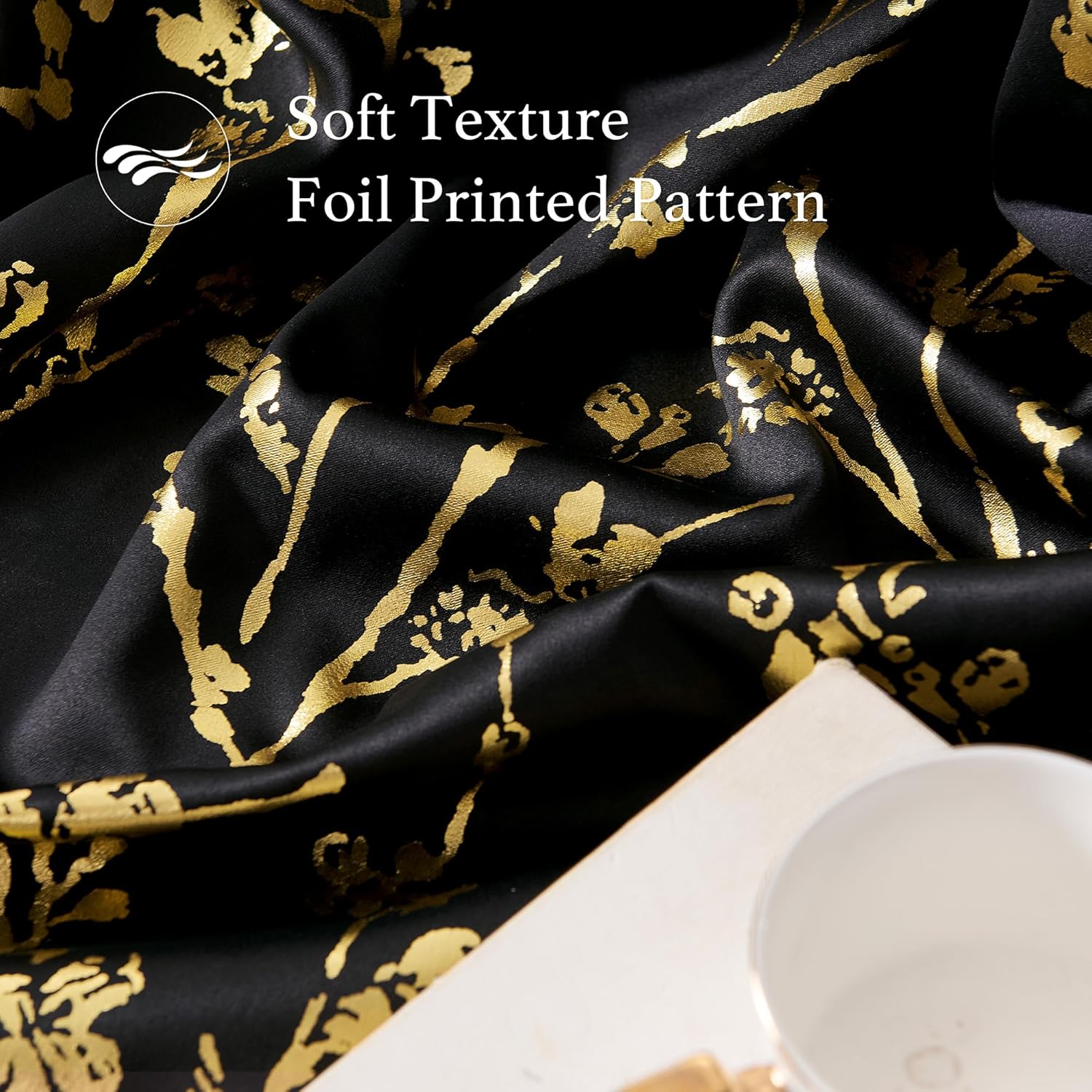 Rich black fabric with a shiny gold foil printed pattern, emphasizing its soft texture.