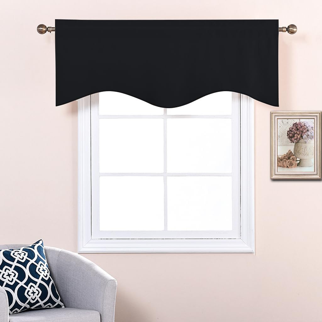 Solid black fabric window valance with a decorative scalloped bottom edge, hung on a brass rod.