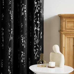 Black curtain with metallic silver cherry blossom branch pattern, enhancing a modern living space.