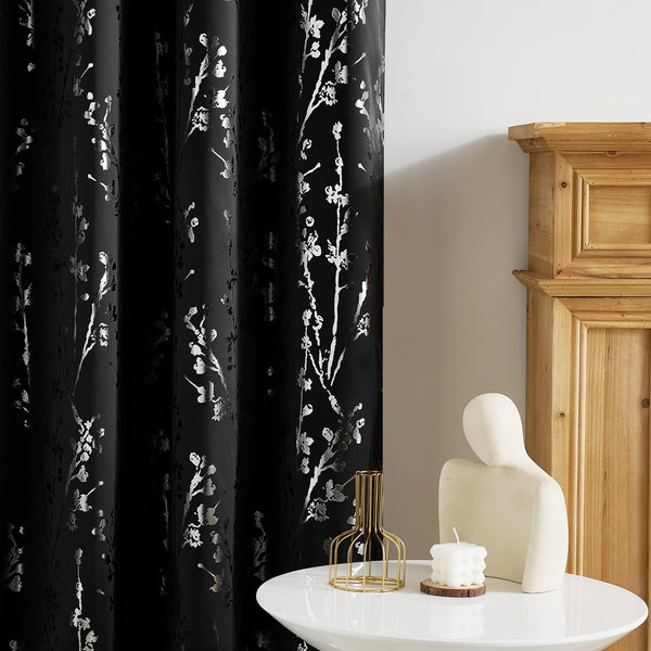 Black curtain with metallic silver cherry blossom branch pattern, enhancing a modern living space.