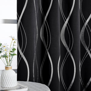 Blackout curtains with shimmering silver wavy lines on a black fabric, elegantly drawn across a window.
