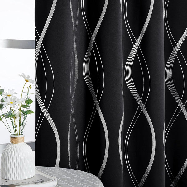 Blackout curtains with shimmering silver wavy lines on a black fabric, elegantly drawn across a window.