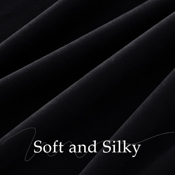 Close-up of soft, silky black fabric with subtle sheen and elegant drapes.