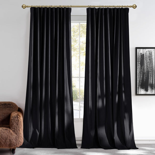 Black luxurious pleated curtains fully drawn over a large window, hung on a brass rod with rings.