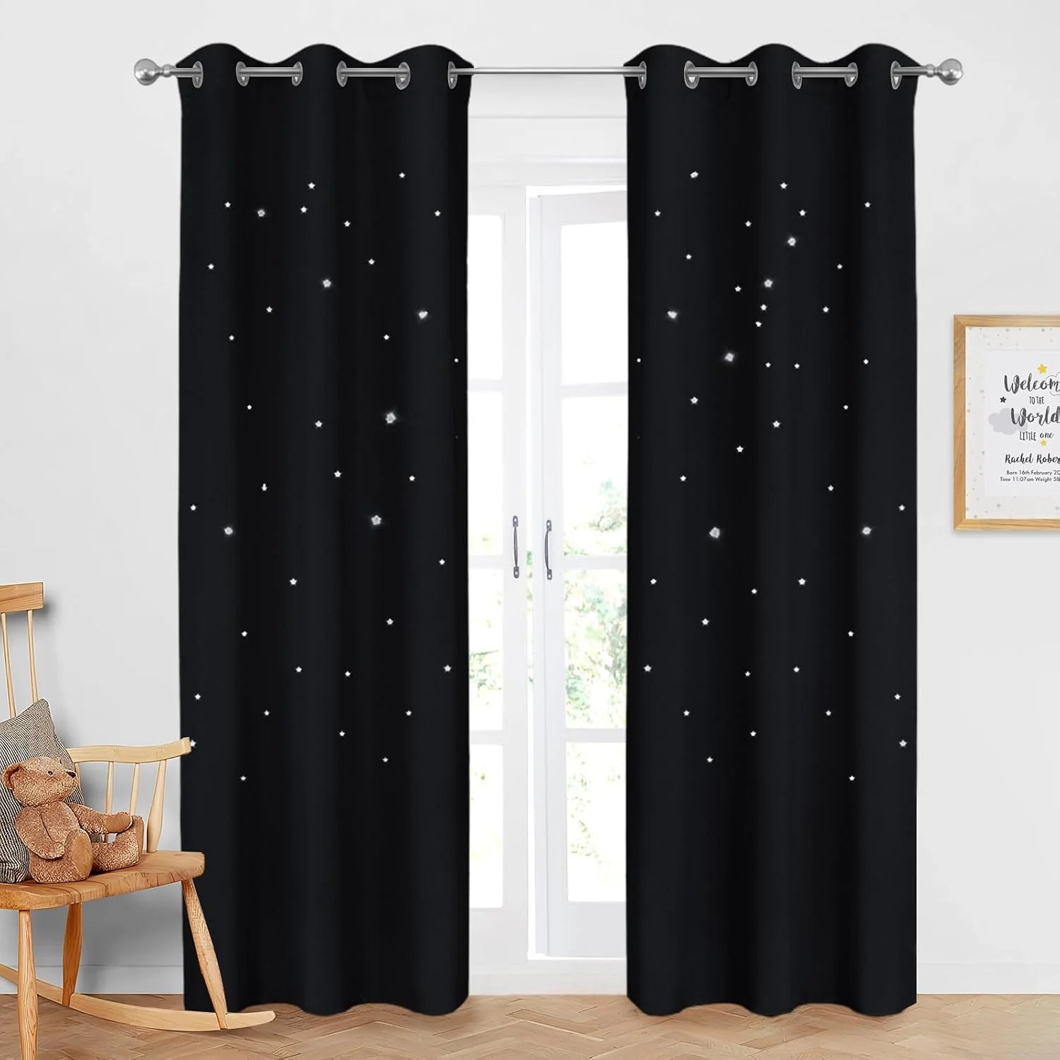 Black grommet curtains with star cutouts hanging in a bright nursery window
