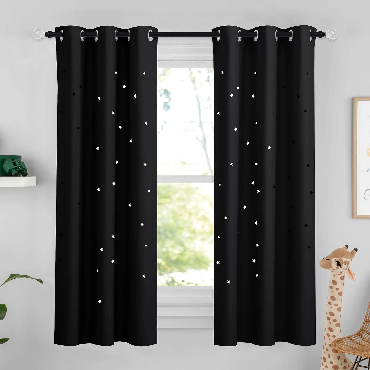 Black star-pattern blackout curtains with silver grommets in a kids room window