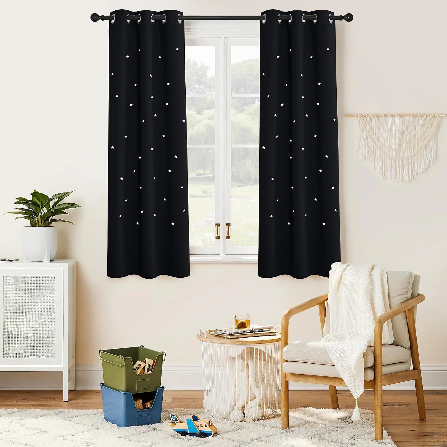 Black star print grommet curtains hanging in a bright cozy kids room