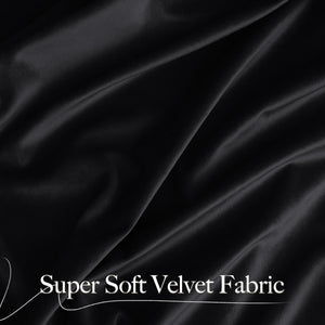 Close-up of luxurious black super soft velvet fabric draped with elegant folds.