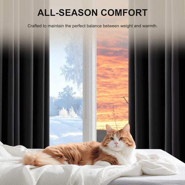 Solid black thermal blackout curtains hang by a window. An orange cat rests on a white blanket.