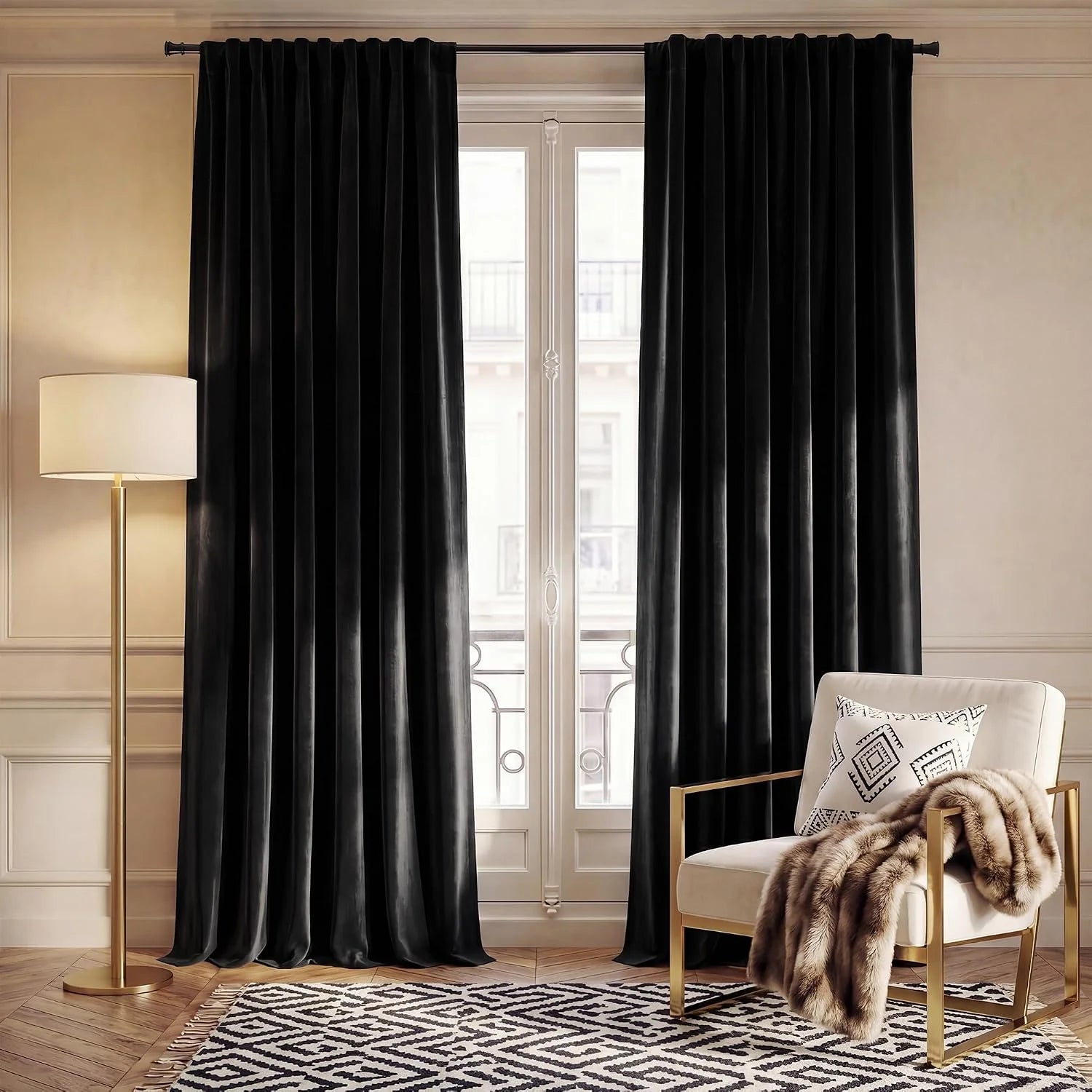 Black velvet blackout curtains hanging on a tall window in a warm modern living room