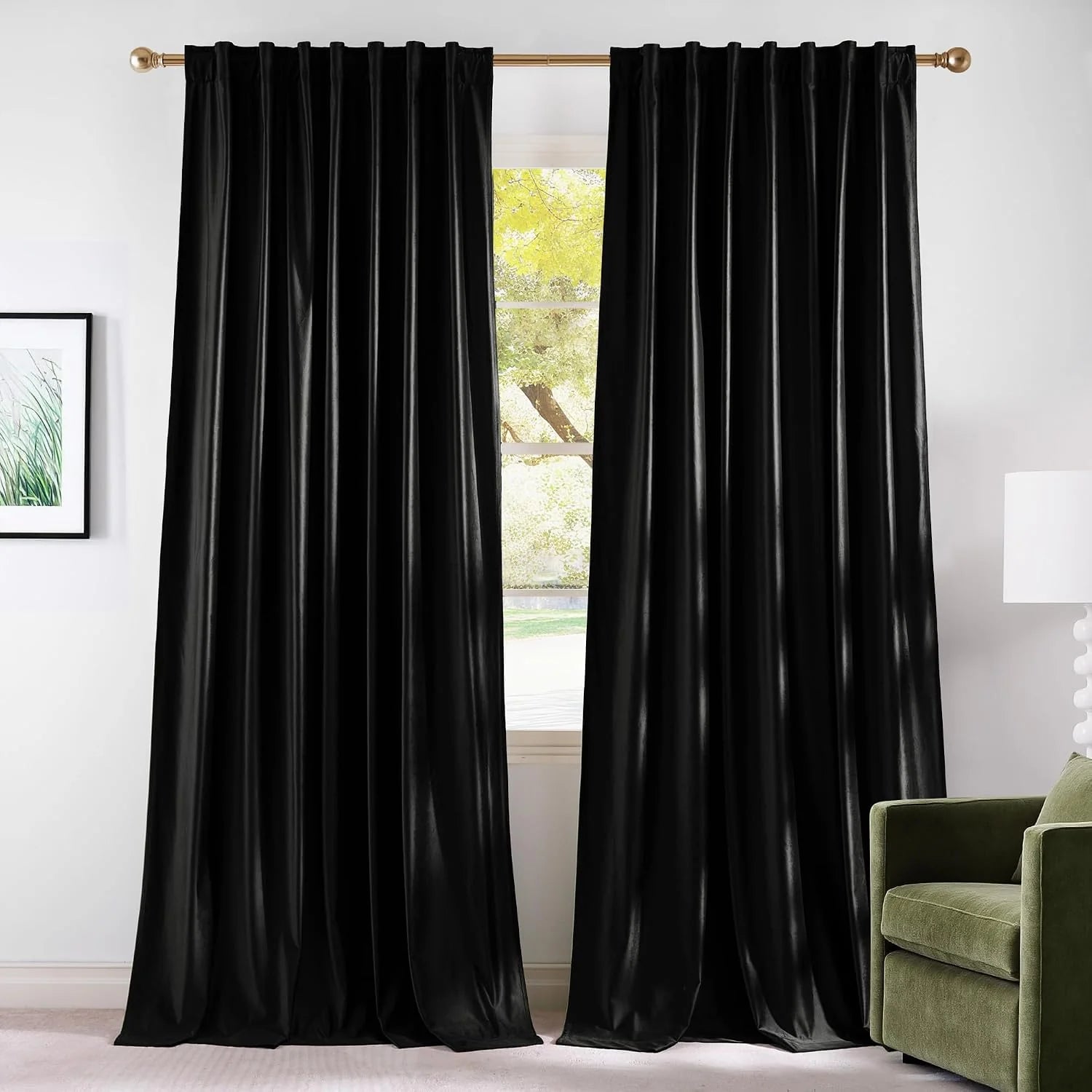 Black velvet blackout curtains on a brass rod in a bright modern living room